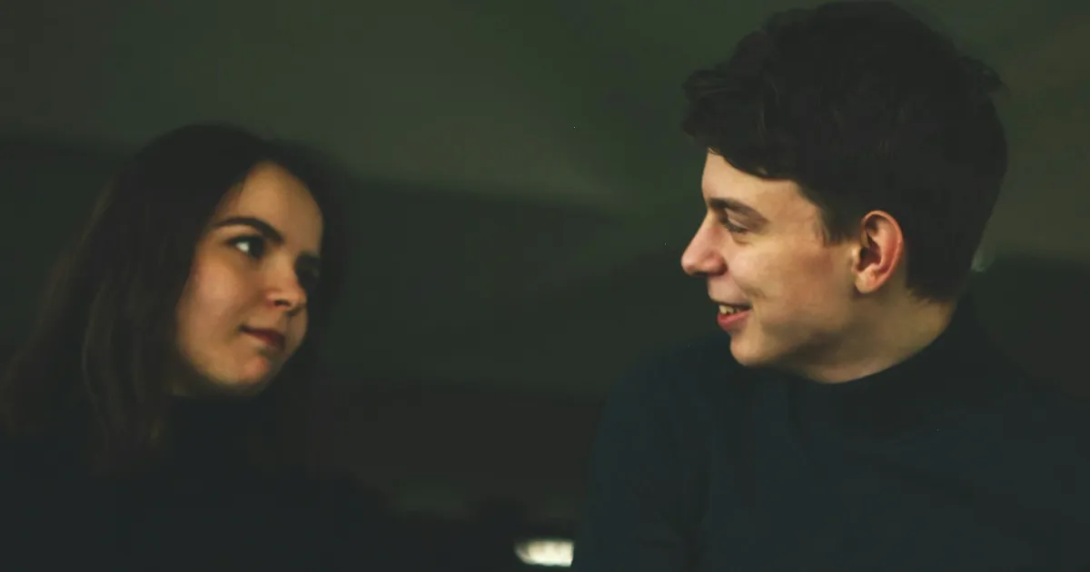 A couple holding deep eye contact in low light