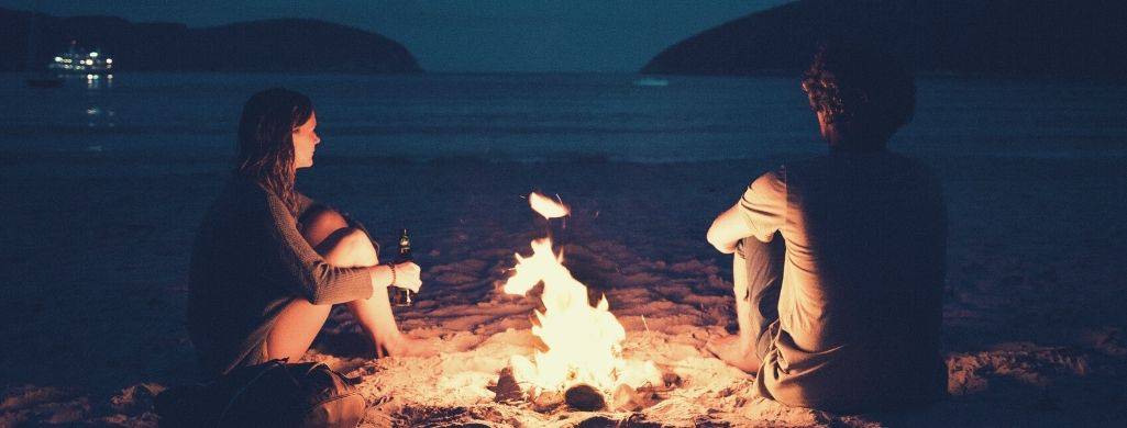 Leo man and a woman sitting near the fire