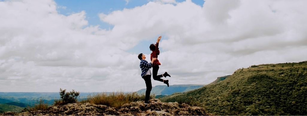 A couple is happy on top of mountain