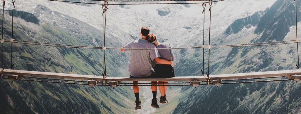 A couple sitting on a bridge